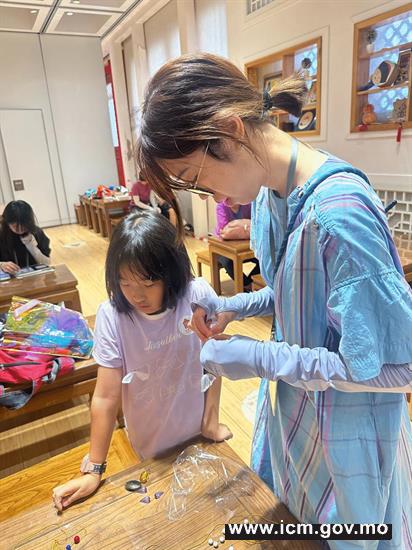 20260325163517_3 社会教育实习生引导儿童观众制作朝珠
